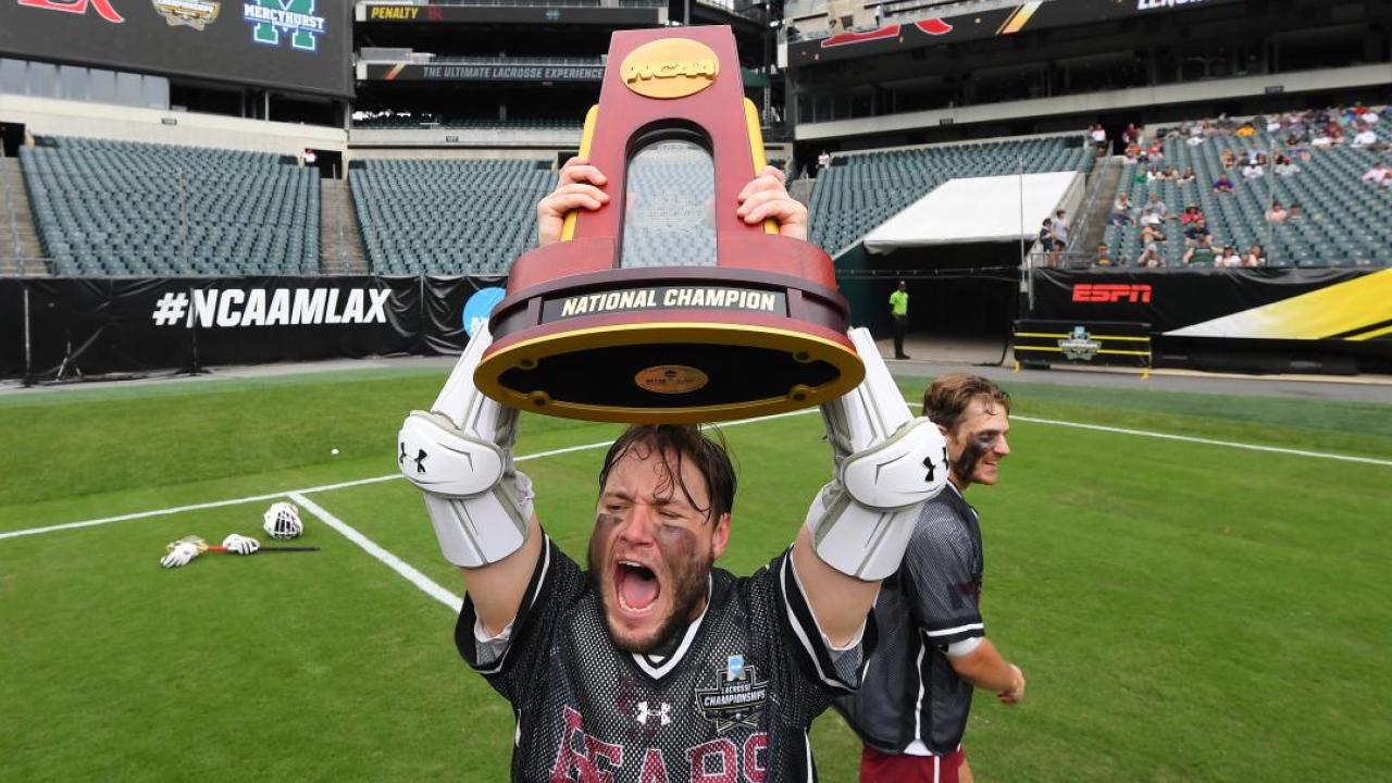 LRU men's lacrosse with trophy