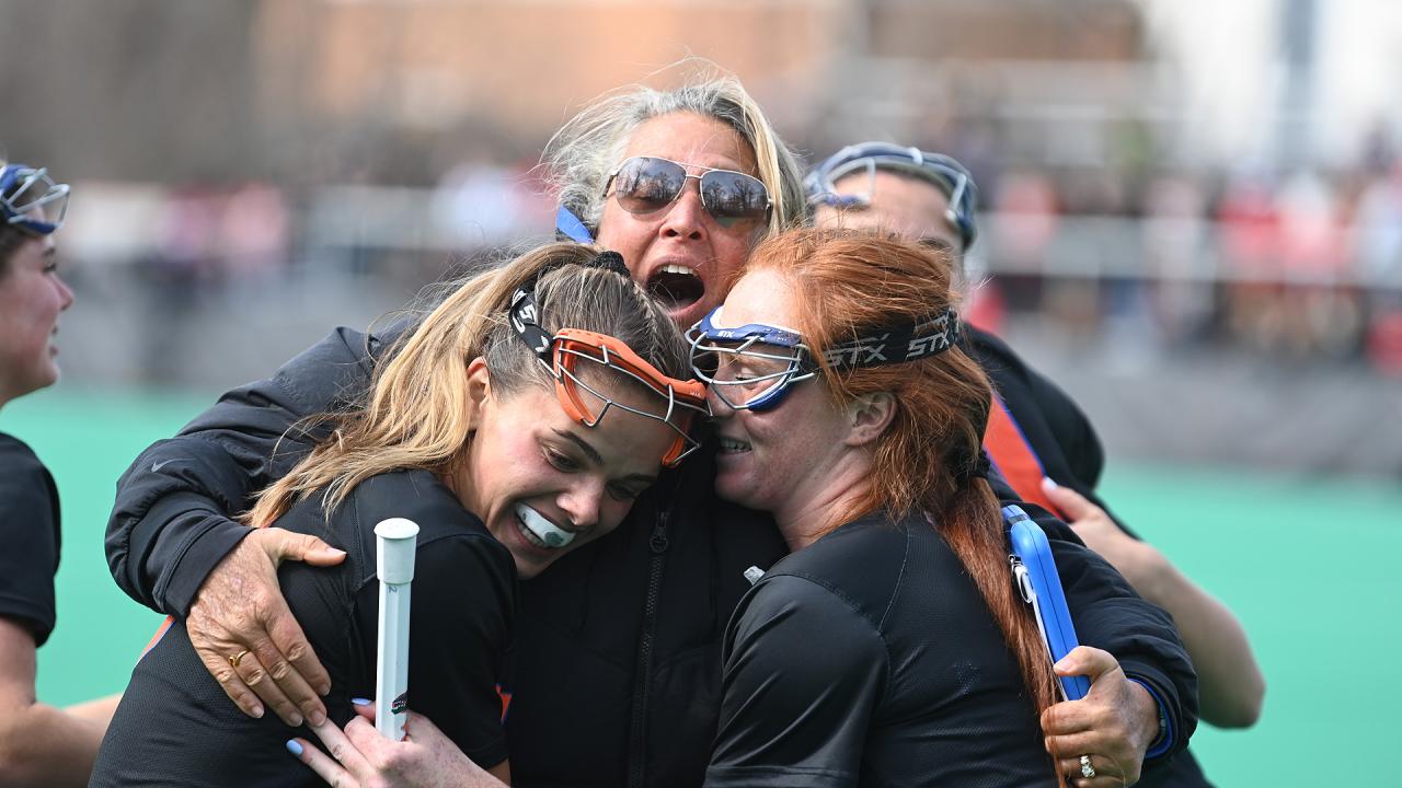 Emily Heller (left) and Madison Waters sandwich coach Amanda O'Leary to celebrate Florida's 13-12 OT win over Maryland in College Park.