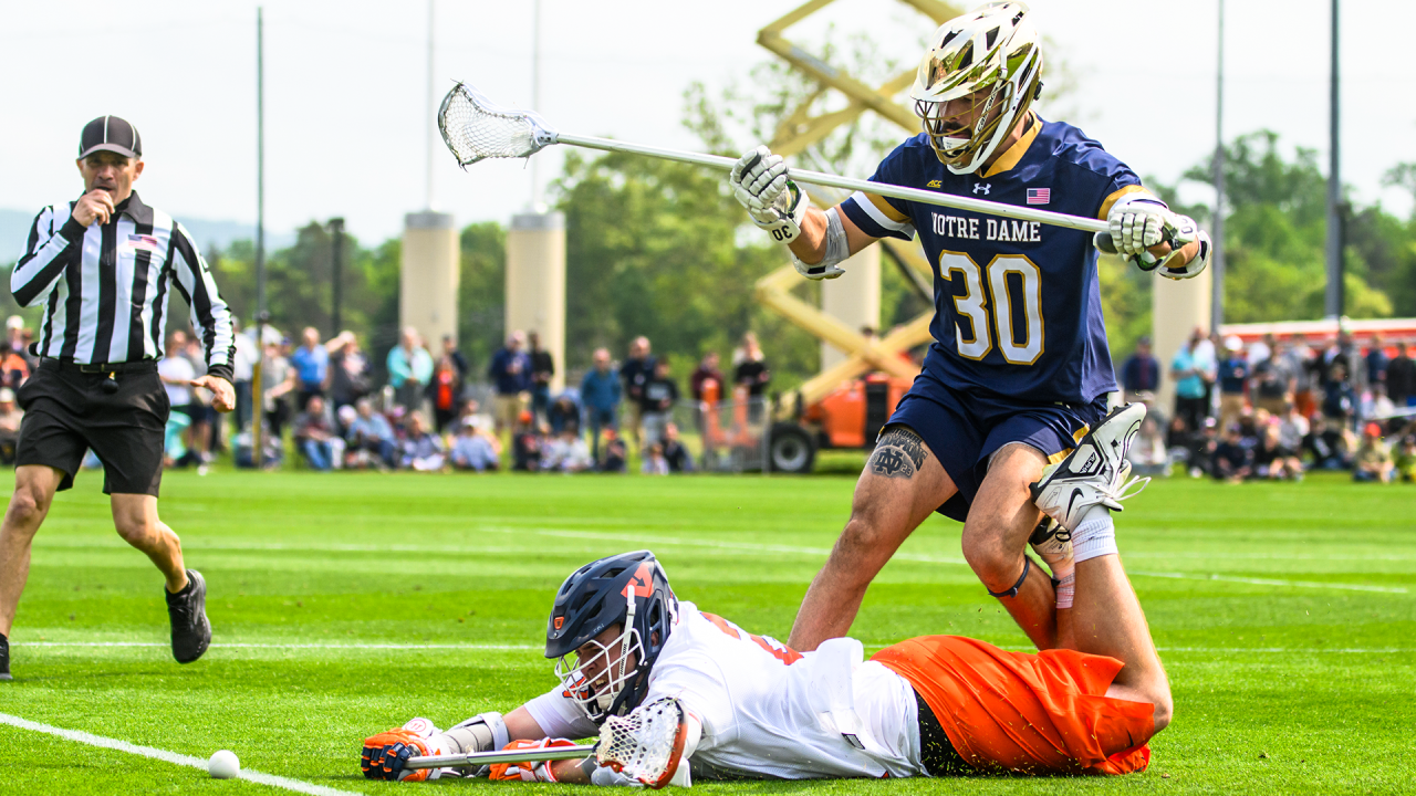 Notre Dame defenseman Marco Napolitano lurks over Virginia attackman Payton Cormier during a game in Charlottesville, Va.