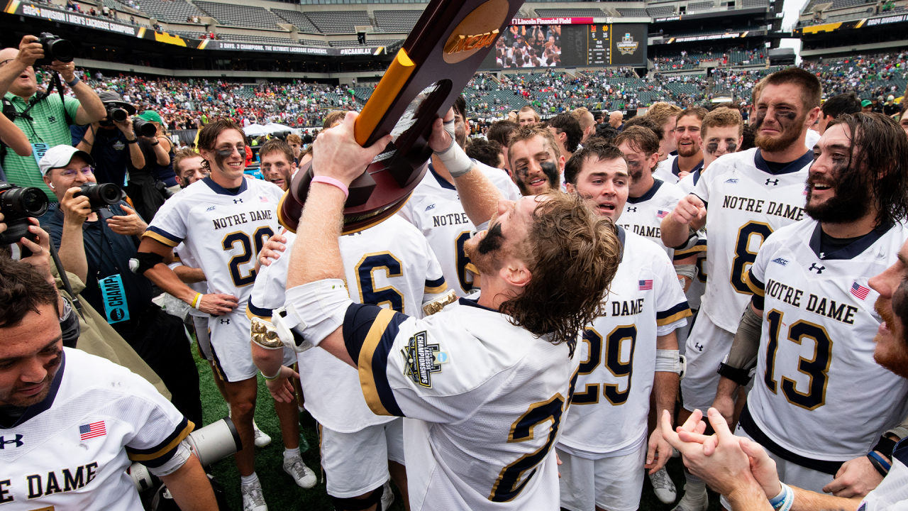 Notre Dame players gather around the NCAA championship trophy.