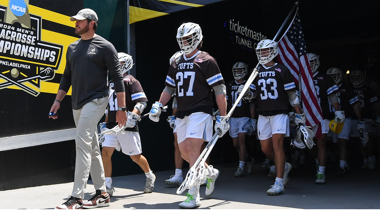 Head coach Casey D'Annolfo leads the Tufts men's lacrosse team out of the tunnel before the NCAA Division III championship game at Lincoln Financial Field in Philadelphia.