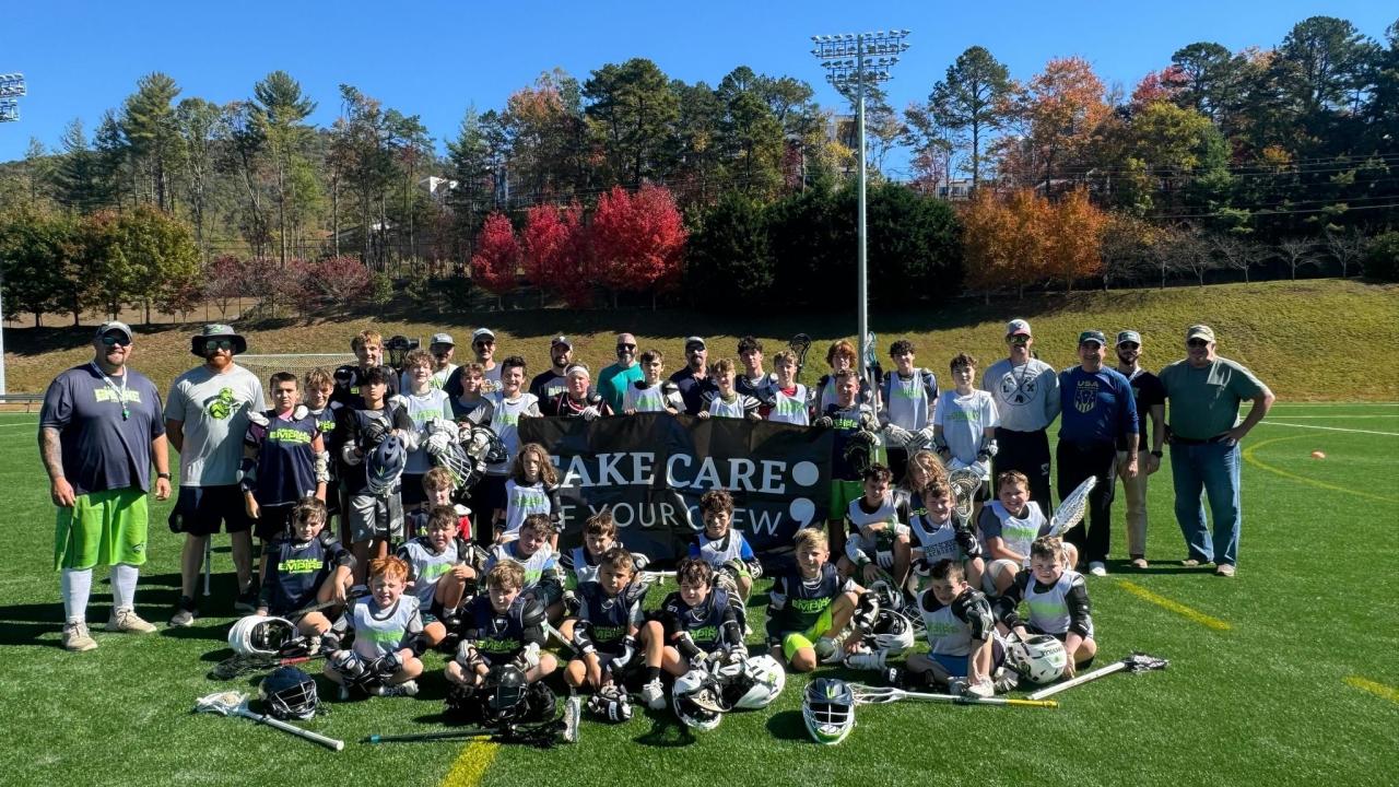 Asheville Empire Lacrosse with sign that reads, "Take care of your crew."